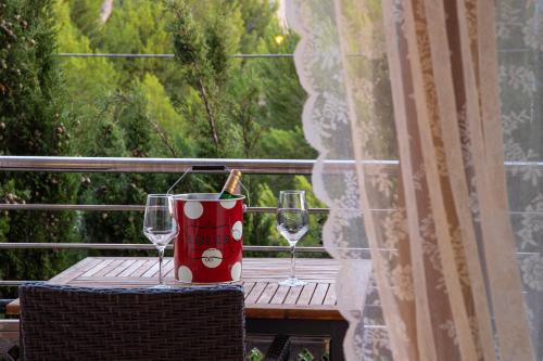 a table with two wine glasses on a balcony at Es Baulo Petit Hotel in Can Picafort