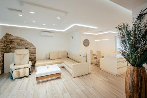 a living room with a couch and chairs and a table at Apartments in Villa Olimp in Ljubljana
