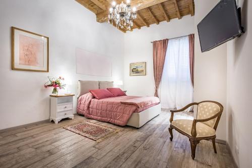 una camera con letto, sedia e televisore di Arno Apartments a Firenze