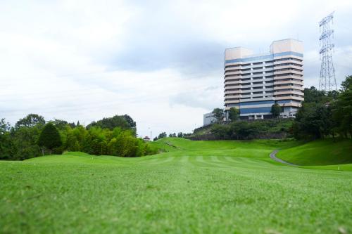 a green golf course with a building in the background at Myogi Green Hotel in Tomioka