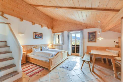 ein Schlafzimmer mit einem Bett und einer Treppe in einem Haus in der Unterkunft Jaudenhof - Apartment Seekaralm in Lenggries