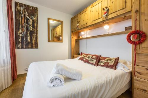 a bedroom with a large white bed with wooden cabinets at Apartment Mummery 1 in Chamonix