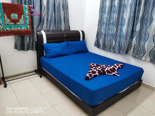 a bed in a room with a blue bed at Zara Homestay in Marang