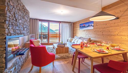 un salon avec une table et des chaises rouges dans l'établissement Les Flambeaux - Apt B02 - BO Immobilier - Multipass été 2025 offert par votre hote, à Châtel