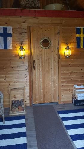 a wooden cabin with two lights and a door at Haga gård och Stall in Herräng