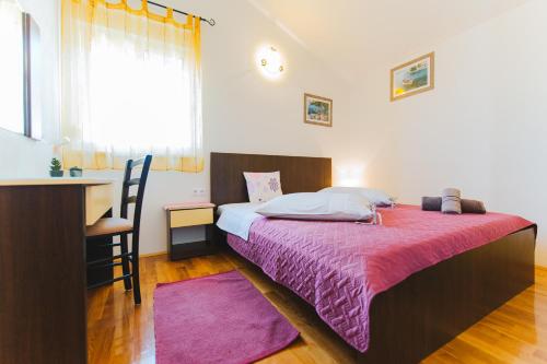 sypialnia z łóżkiem, biurkiem i oknem w obiekcie Apartmani Villa Marija w Omišu