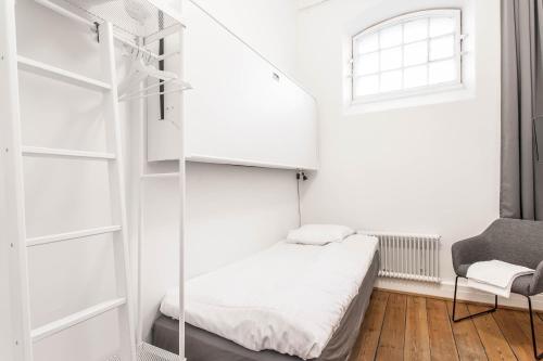 a small bedroom with a bed and a window at Kronohäktet in Karlskrona