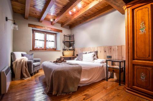 um quarto com uma cama e uma cadeira em BARN THE RETREAT Acogedor apartamento en Arties em Arties