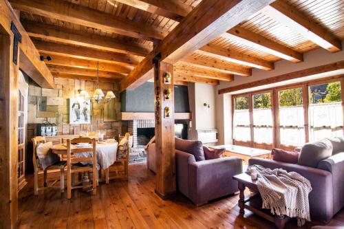 a living room with wooden ceilings and a dining room at BARN THE RETREAT Acogedor apartamento en Arties in Arties
