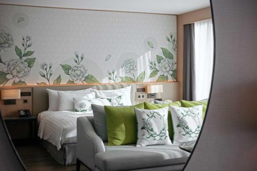 a bedroom with a bed with green and white pillows at Sivatel Bangkok Hotel in Bangkok