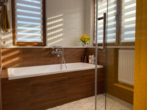 a bathroom with a bath tub and a window at Klinkierowy Apartament z wanną dla Dwojga in Gniezno