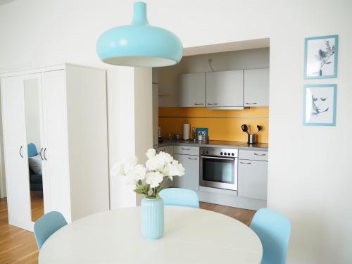 a kitchen with a table with a vase of flowers on it at APSTAY City Residence Apartments ǀ Parking option & Self Check-in in Graz