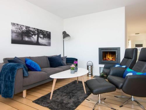 a living room with a couch and a fireplace at 4 person holiday home in Ebeltoft in Ebeltoft