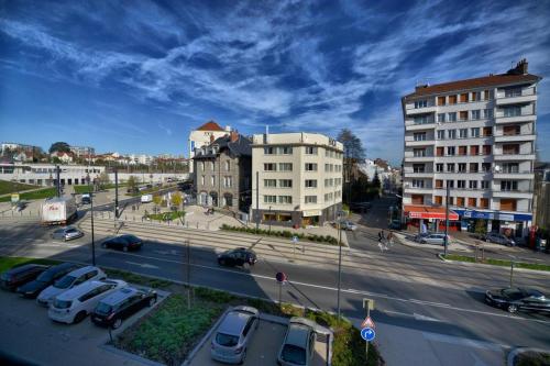 una ciudad con coches estacionados en un estacionamiento en Appartment Les Suites Du Parc en Besançon