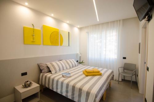 Un dormitorio con una cama con una maleta amarilla. en VARESE COMFORT ROOM en Varese