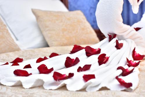 a person is arranging red roses on a bed at Hotel Chao in Batumi