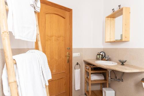 a bathroom with a sink and a wooden door at APARTAMENTO EL ROJO in Can Picafort