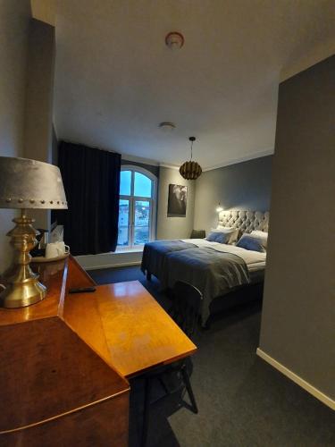 a bedroom with a bed and a table with a lamp at Hotell Carl Friman in Motala