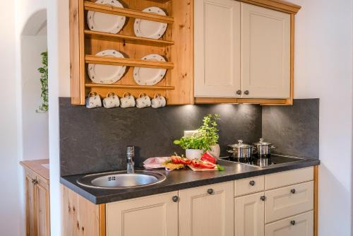 a kitchen with a sink and wooden cabinets at Beim Paulfischer - Eckbankerl in Chieming