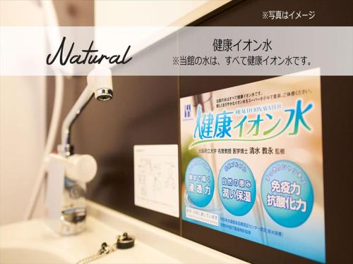 a bathroom mirror with a sign above a sink at Super Hotel Premier Saitama Higashiguchi in Saitama