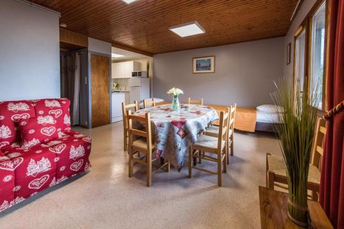 une salle à manger avec une table et un canapé dans l'établissement Les Sorbiers Appartements, à Montricher-Albanne