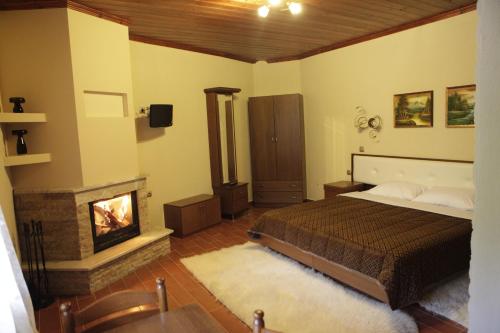 ein Schlafzimmer mit einem Bett und einem Kamin in der Unterkunft Xenonas Platia in Kato Loutraki