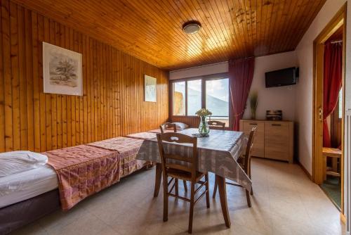une chambre avec un lit et une table avec des chaises dans l'établissement Les Sorbiers Appartements, à Montricher-Albanne