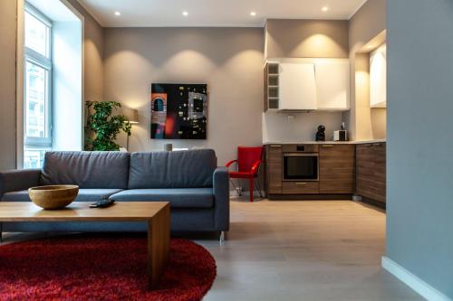 sala de estar con sofá azul y cocina en Forenom Serviced Apartments Bergen City, en Bergen