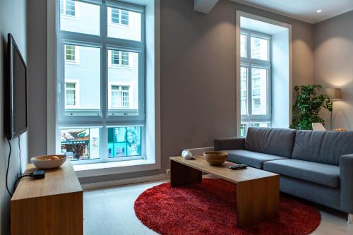 a living room with a couch and two windows at Forenom Serviced Apartments Bergen City in Bergen