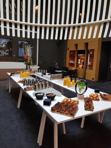 a long table filled with different types of food at Golden Tulip Saint Malo– Le Grand Bé in Saint Malo