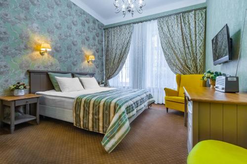 a hotel room with a bed and a yellow chair at Blues na Nevskom in Saint Petersburg