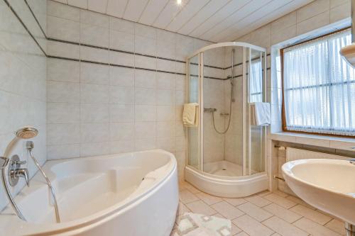 a bathroom with a tub and a shower and a sink at Katharinenhof Ferienwohnung Kramer Groß (3) in Garmisch-Partenkirchen