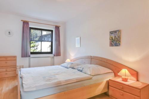 Un dormitorio con una cama grande y una ventana. en Katharinenhof Ferienwohnung Kramer Groß (3), en Garmisch-Partenkirchen