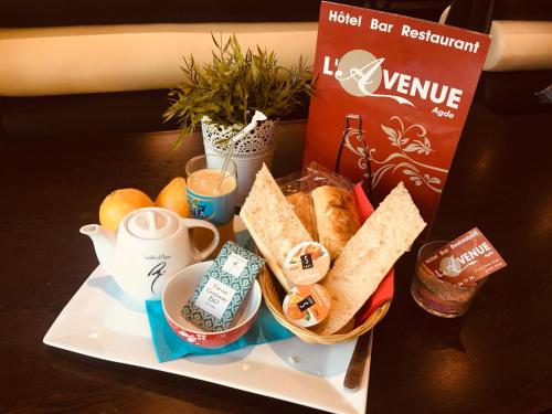 une assiette de nourriture avec du pain, du café et un service à thé dans l'établissement L'Avenue, à Agde