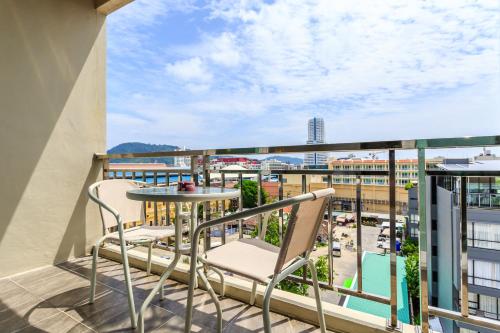 a balcony with a table and chairs and a view of a city at 77 Bangla Hotel - Patong Phuket in Patong Beach