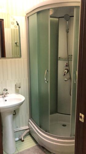 a bathroom with a shower and a sink at Mereke Hotel in Ustʼ-Kamenogorsk
