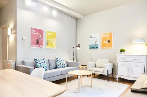 uma sala de estar com um sofá e duas cadeiras e uma mesa em Bergara Apartment by BasqueHomes em San Sebastián