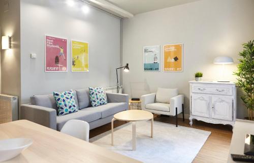 uma sala de estar com um sofá, uma cadeira e uma mesa em Bergara Apartment by BasqueHomes em San Sebastián