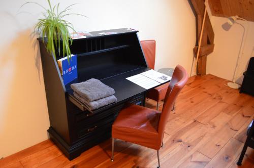 a desk with a chair and a laptop on it at B&B de Bievangh in Breda