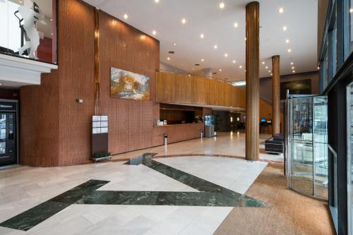 un vestíbulo de un edificio con ascensor de cristal en Catalonia Gran Hotel Verdi, en Sabadell