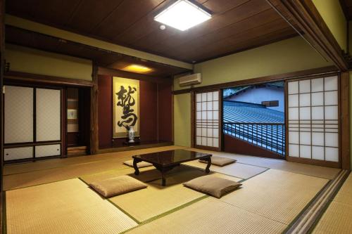 um quarto com uma mesa e algumas janelas em 宿坊 端場坊｜Temple Hotel Habanobo em Minobu