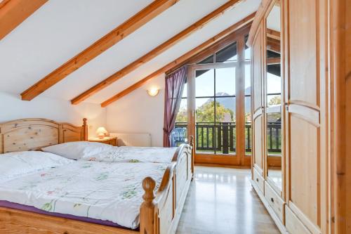 Un dormitorio con una cama y una ventana grande. en Katharinenhof Ferienwohnung Zugspitze (5), en Garmisch-Partenkirchen