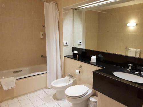 a bathroom with a toilet and a sink and a tub at Basingstoke Country Hotel & Spa in Hook