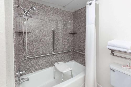 a bathroom with a shower and a bath tub at Super 8 by Wyndham Clinton in Clinton