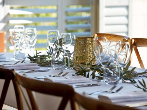 a table with wine glasses on top of it at Pullman Bunker Bay Resort Margaret River in Dunsborough