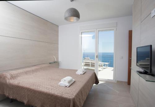 a bedroom with a bed and a view of the ocean at Sueño Azul in Jávea