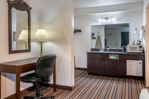 a hotel room with a desk and a mirror at Quality Inn Central Roseburg in Roseburg