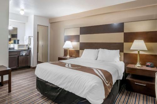 a hotel room with a large bed and a kitchen at Quality Inn Central Roseburg in Roseburg