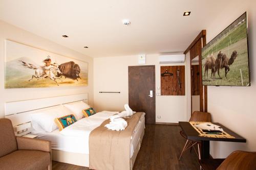 Residence Safari Resort - Bison Lodge في Borovany: غرفة نوم بسرير وطاولة واريكة