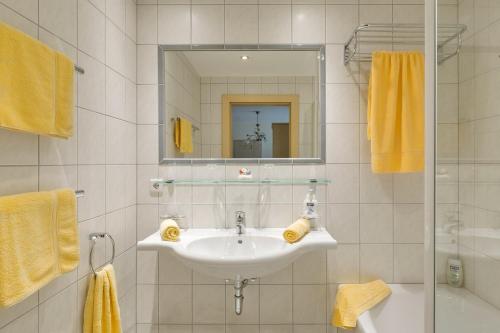 a white bathroom with a sink and a mirror at RAFFL APART in Sankt Anton am Arlberg